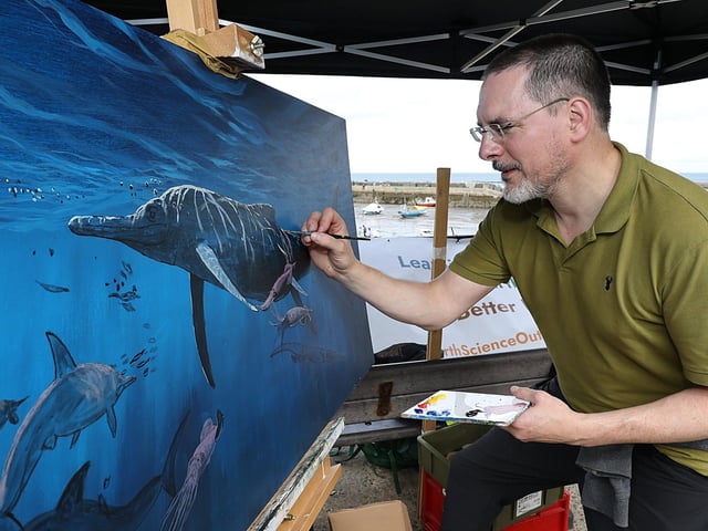 Paleo Artist James Makay working on his latest painting. photo: Richard Ponter