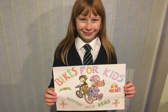 Daisy shows off her Bikes for Kids poster