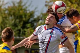 Whitby Town's Aaron Cunningham challenges for a header at Marske United