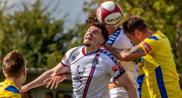 Whitby Town's Aaron Cunningham challenges for a header at Marske United