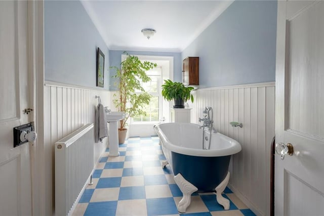 A light and airy bathroom with a free standing, claw foot and roll-top bath.