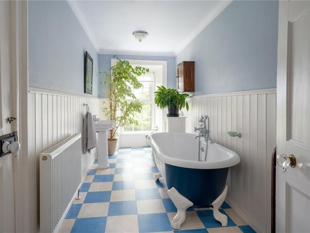 A light and airy bathroom with a free standing, claw foot and roll-top bath.