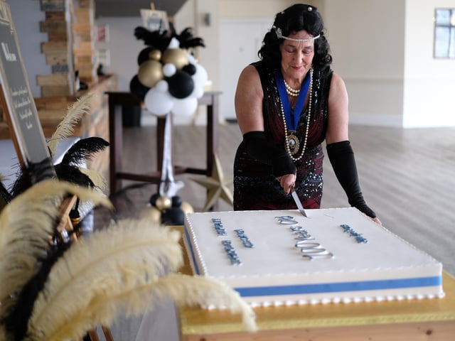 President Shirley Smith cuts the cake.