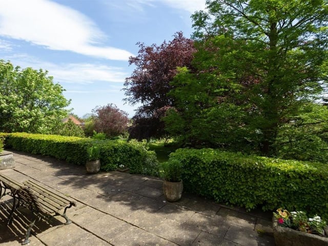 A patio seating area within the garden, that has views over to the sea.