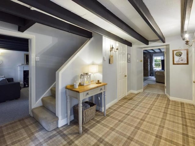 A welcoming hallway with ceiling beams, that are a feature throughout ground floor rooms.