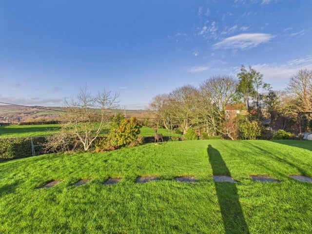 The lawned garden with scenery beyond.