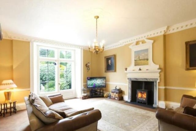 A large living room with feature fireplace and French doors to outside.