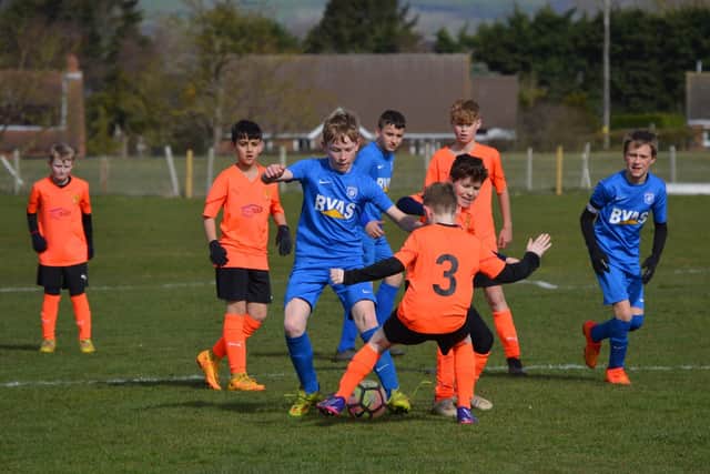 Hunmanby U12s get stuck in against Heslerton Spiders.