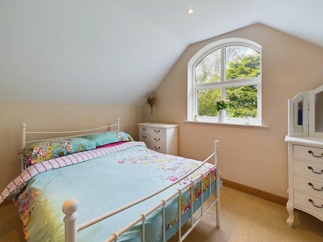 A quaint double bedroom with an arched window.