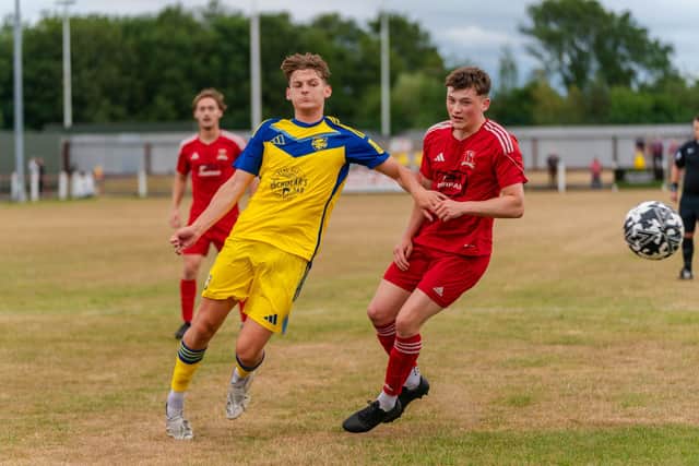 Billy Marshall holds off a Selby Town player. Photo by Wandering Photography