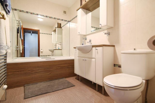The family bathroom is modern in style and is generously sized to comprise a bath, toilet and wash basin, and vanity storage.