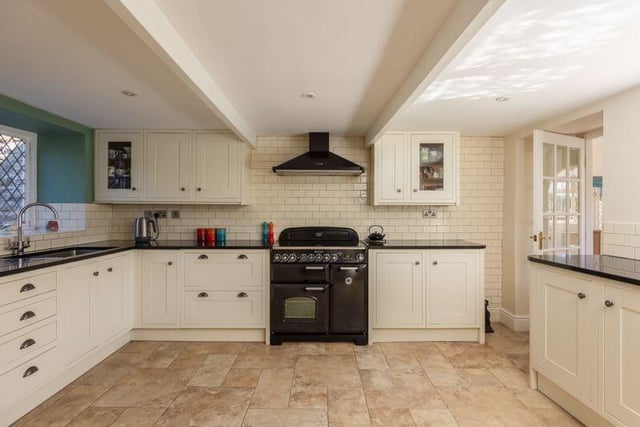 The spacious, modern kitchen has solid woor and granite-topped units.