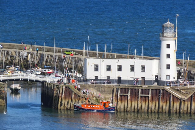 Lighthouse and the old lifeboat pleasure boat.