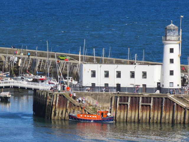 Lighthouse and the old lifeboat pleasure boat.