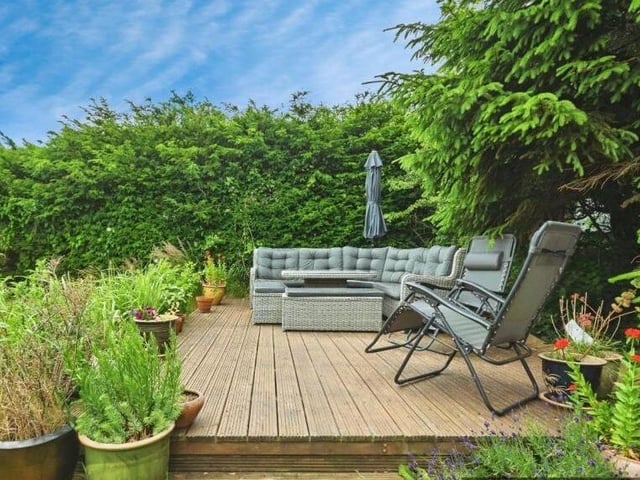 A raised, decked seating area in the garden.
