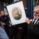 Pete Thomson receiving a photo of Harry Robbins, master of arms on the Rohilla.