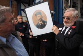 Pete Thomson receiving a photo of Harry Robbins, master of arms on the Rohilla.