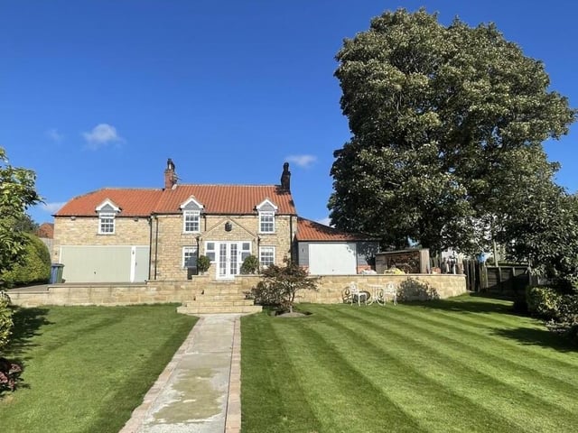 There are lawned gardens to the front, and a rear courtyard garden.