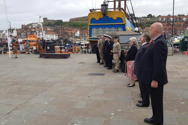 The Town Mayor and representatives of the Armed Forces look on.