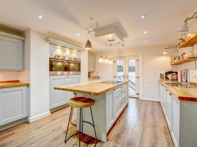 The bespoke kitchen with central island has a range of integrated appliances.