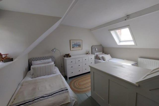 This bedroom has  a fireplace and sash window, plus a Velux window.