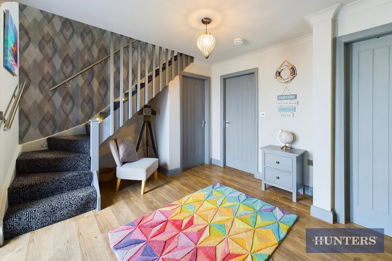 The welcoming hallway with angled staircase up.