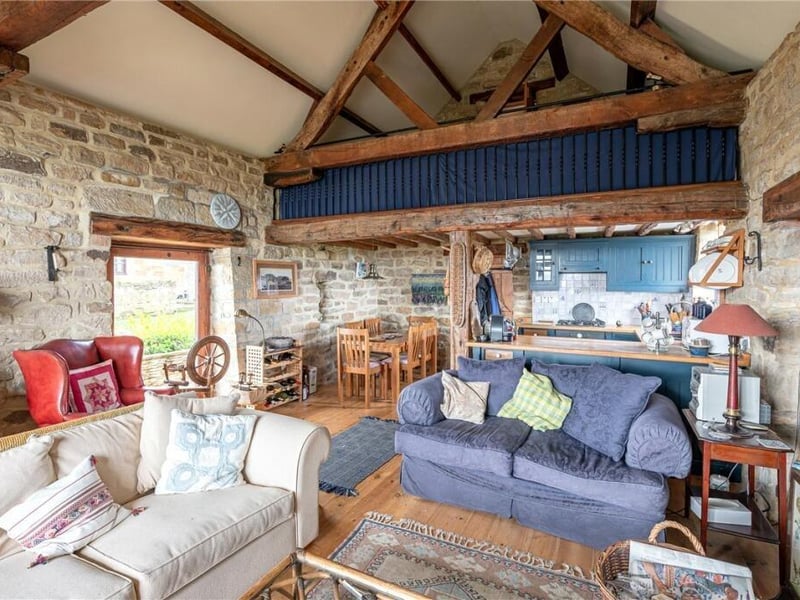 Rustic style, open plan living with stone walls and vaulted ceiling.