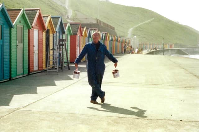 Ben Kelly in front of Whitby's iconic beach huts.