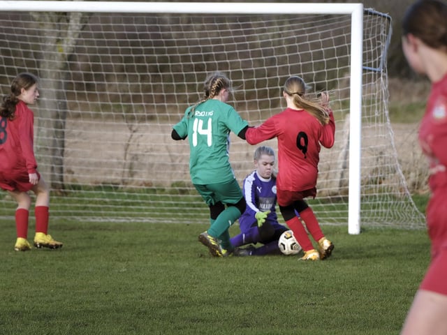 Goalmouth action as the Wigginton Grasshoppers goalkeeper tries to gather the football.