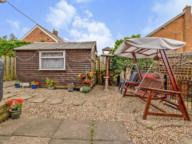 The attractive rear patio area. The property has a garage, and parking for at least three cars.