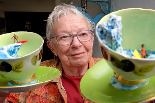Gallery owner Leslie Stones holds Storm in a Tea Cup - sculptures by Simon Doughty