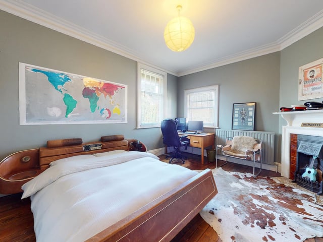 A double bedroom within the house, with a period fireplace.