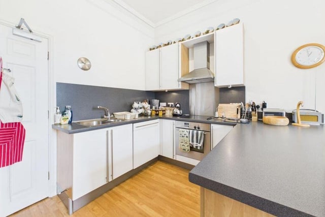A modern kitchen through to diner has fitted units with integrated appliances.