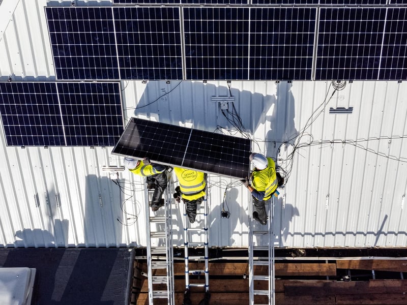 Solar engineers fix a row of solar panels on the roofs. Photo by Toby Smith / Good Energy.