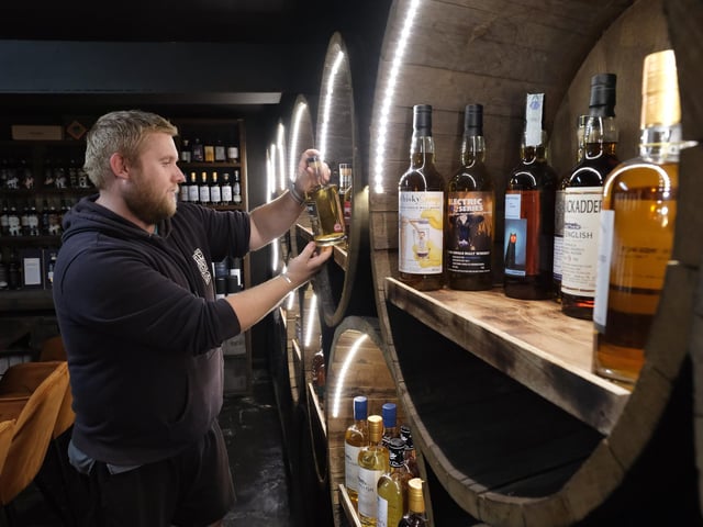 Matt Dugdale selects a bottle from the shelves