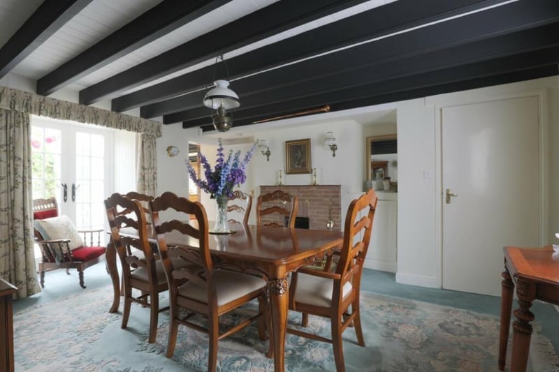 The beamed dining room with feature brick fireplace.