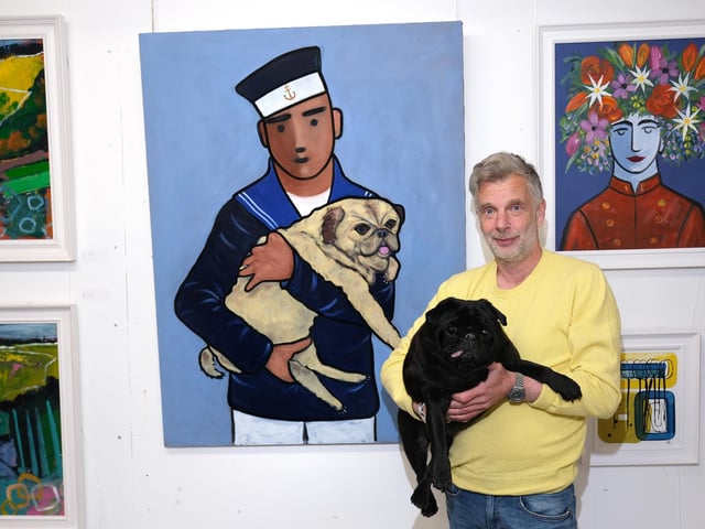 Adam King, viewing his work with a furry friend.