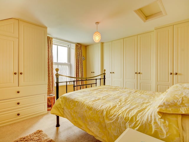 A bright double bedroom with fitted furniture.