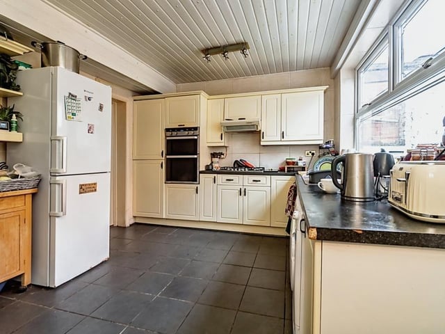 The kitchen in this property is fitted with shaker style units, and includes an eye level double oven and gas hob. A window overlooks the garden and there's an adjacent utility room.