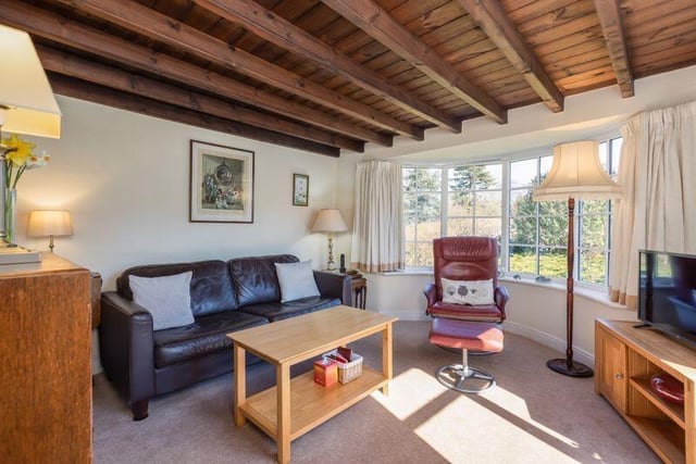A wide bay window allows light to flood in while displaying views of the garden.