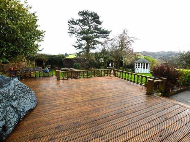 A large decked seating area in the garden overlooks the valley.