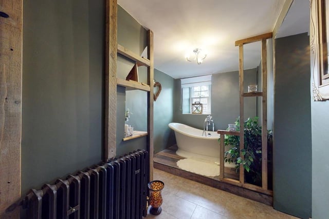 A stylishly fashioned bathroom with roll top bath.