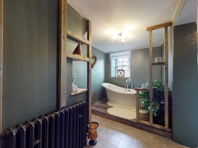 A stylishly fashioned bathroom with roll top bath.