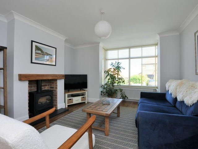 A lounge with log burner in feature fireplace.