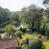 The picturesque gardens of the property, with ponds and open countryside beyond.