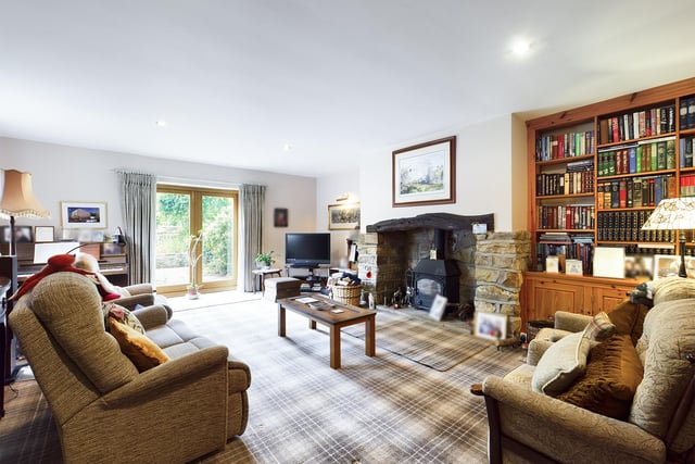 A room to relax in - with a feature stone fireplace and double doors leading out to the gardens.