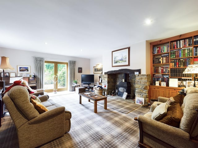 A room to relax in - with a feature stone fireplace and double doors leading out to the gardens.