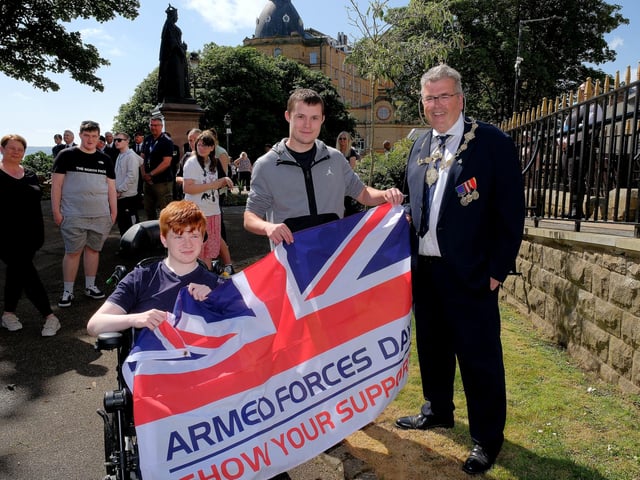 Mayor John Ritchie hands over The Armed Forces Flag to Springhead pupils Jaydon Culley and Travis McCallion