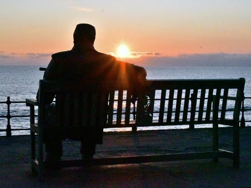 The iconic "Freddie Gilroy" sculpture by Ray Lonsdale, framed by the setting sun.