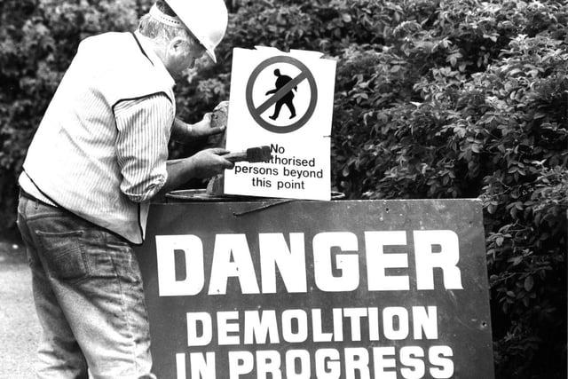 A warning sign is erected by demolition experts.